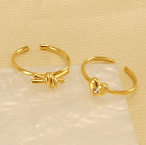 Detailed shot of 18K gold plated adjustable open rings with heart and knot designs
