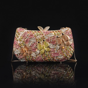 Detail of a luxury champagne bottle clutch featuring multi-colored crystals and a bow clasp