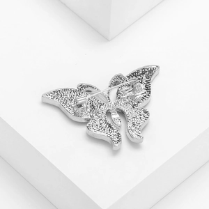 Back view of silver butterfly brooch with abalone shell details on white pedestal