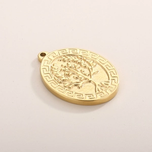 Macro shot of gold tree of life pendant with Greek meander border pattern engraving