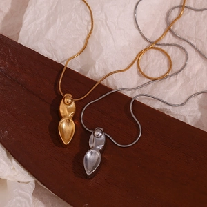 Détail de pendentifs gouttes d'eau abstraites en or et argent sur chaînes serpent