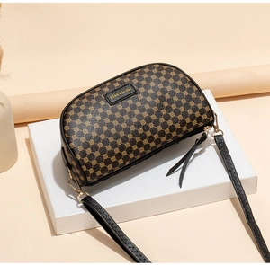 Detail of printed saddle bag in brown faux leather with adjustable strap on white gift box