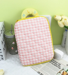Detail of pink plaid quilted iPad sleeve with yellow embroidered Melody handle