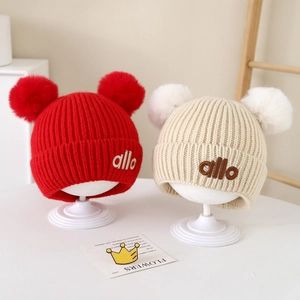 Baby-Wintermützen in Rot und Beige mit flauschigen Doppelbommeln und gesticktem Logo