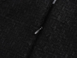 Détail macro du tissu en tweed noir de qualité et fermeture éclair invisible sur la robe