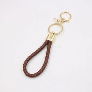 Close-up of brown braided leather keychain with golden D-ring and metal keyring