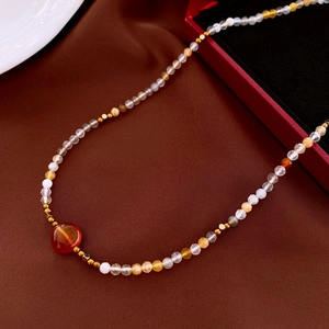 Detailed view of beaded necklace featuring red focal stone and mixed crystal beads