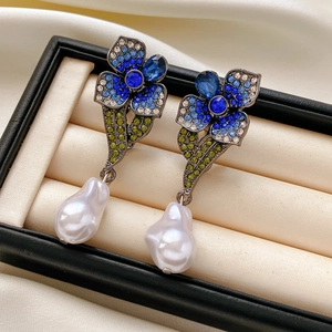 Détail macro de boucles d'oreilles vintage avec cristaux bleus et perles baroques