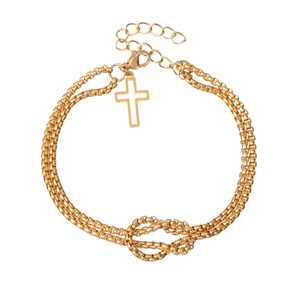 Close-up of gold double-layer chain bracelet with knot design and cross charm