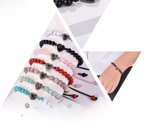 Detail of pink zebra stone bracelets with 100 languages heart projection pendant charms