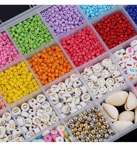Macro view of 24-compartment storage box with colorful seed beads and letter charms