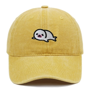 Close-up of cute white seal embroidery on a yellow washed cotton baseball cap texture