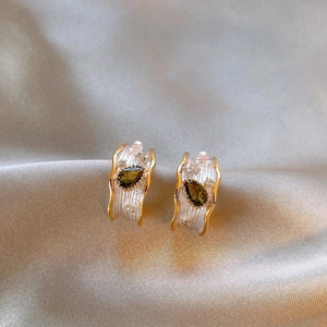 Close-up of French vintage silver earrings with green pear-shaped zircon and pearls
