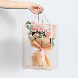 Detailed view of clear PVC gift bag with pink floral bouquet and peach ribbon handle