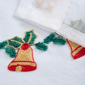 Detail of Christmas bell embroidery on white fabric with gold and red threads