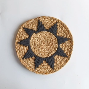 Bohemian round straw wall decor with blue geometric pattern on natural fiber base