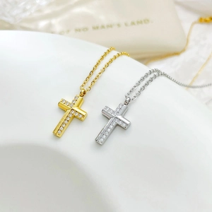Cross necklaces in gold and silver with cubic zirconia inlays on wave display stand