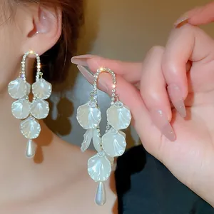 Détails macro de boucles d'oreilles pétales avec accents de diamants et perle