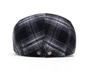 Rear view of a vintage plaid newsboy cap showing metallic buttons and fabric texture