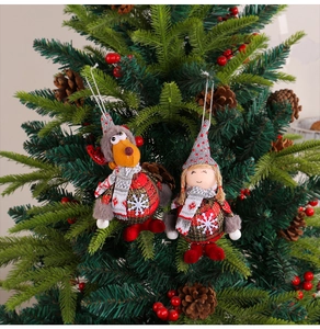 Detailed plush reindeer and gnome ornaments hanging on a Christmas tree branch