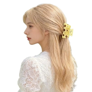 Creative yellow hollow cheese-shaped hair claw clip worn on blonde hair for cute styling