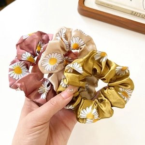 Three-piece set of daisy print satin hair scrunchies in pink, beige, and yellow colors