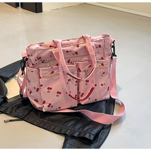 Close-up of pink cherry print tote bag with multi-zipper pockets and shoulder strap