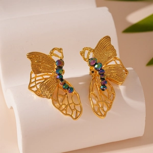 Detail of golden butterfly stud earrings featuring faceted colored beads and mesh texture