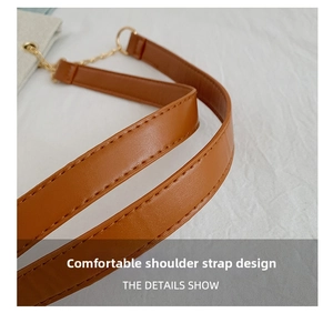 Detail of brown PU leather shoulder strap with golden metal rings and neat stitching