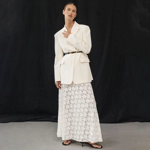 Detail of high waist white lace skirt with floral patterns and sheer fabric texture