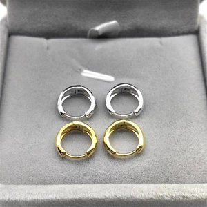 Detailed view of silver and gold S925 sterling silver hoop earrings in a grey velvet box