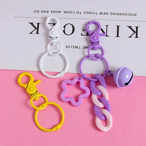 Colorful metal lobster clasp keychains with purple star and bell pendants on magazine base