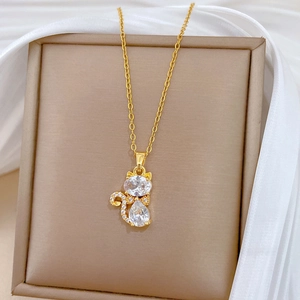 Vue détaillée d'un pendentif chat doré avec des zircons brillants sur son écrin