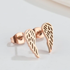 Macro shot of rose gold wing stud earrings with intricate cutout feather detailing