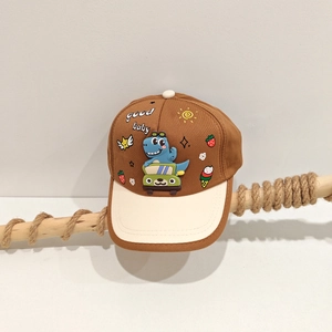 Detail of cartoon dinosaur print and 'good baby' embroidery on kids baseball cap