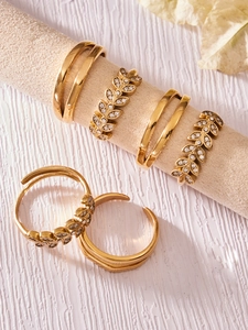 Detail showing gold leaf rings with zircons and minimalist double-line stacked ring set