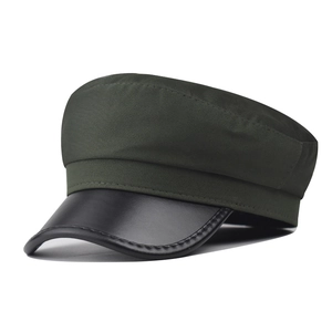 Close-up of olive green fabric texture and black leather brim on the baker boy cap