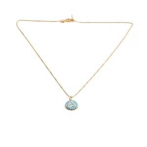 Close-up of gold-plated chain featuring a blue enamel Be Free bottle cap pendant