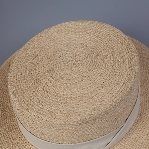 Vue de dessus d'un chapeau de paille en raphia montrant le tissage en spirale précis