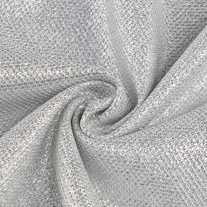 Detailed macro view of sparkling silver sequin fabric texture with a spiral layering effect