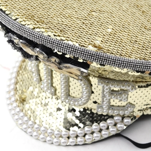 Close-up of champagne gold sequin captain hat with pearl Bride lettering and rhinestones