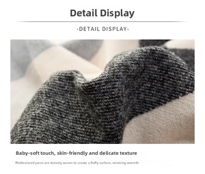 Close-up of thick plaid cashmere feel scarf featuring grey and white woven texture