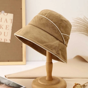 Detail of khaki cotton linen sun hat featuring cream contrast piping and sturdy canvas texture