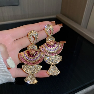 Luxurious bohemian style gold earrings with red and pink crystals in a fan-shaped design