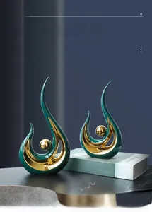 Detail of modern abstract ceramic sculpture in deep teal glaze with gold sphere accent