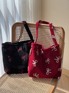 Vintage canvas tote bags with bow embroidery and corduroy texture on a wicker chair