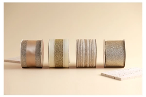Detail of four champagne Christmas ribbons with glitter, satin, and mesh textures