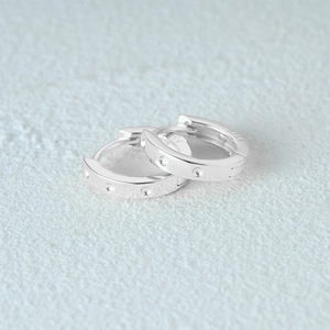 Close-up of S925 sterling silver hallmark engraved on wide hoop earrings band