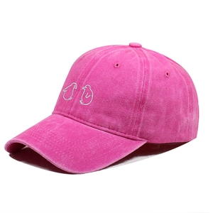Detailopname van roze gewassen katoenen baseballcap met schattig wit pinguïnborduursel