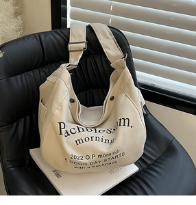Détail du sac fourre-tout en toile montrant l'imprimé Pachblossom sur un canapé noir